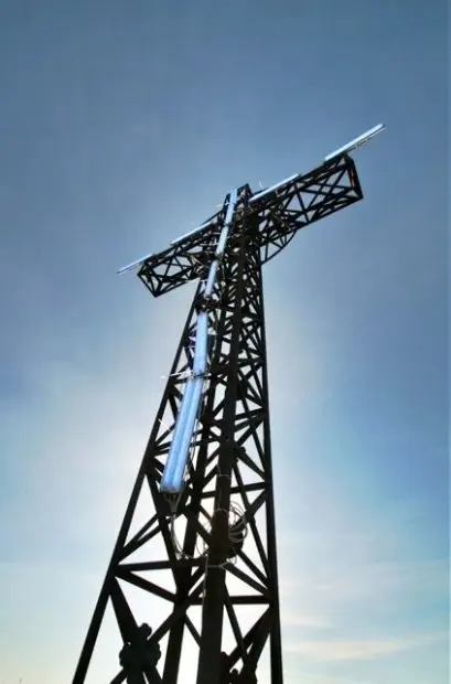 Blue neon lights attached to the cross at the top of Monte Acuto